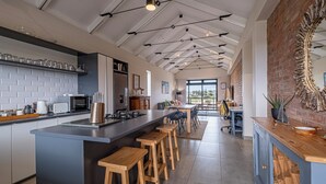 Une cuisine moderne dotée d’un îlot central, de tabourets de bar et d’un grand miroir.