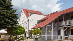 Ein Gebäude mit rotem Ziegeldach, einer Treppe und einem Schild, auf dem 'Pension' steht.