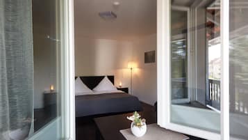Une chambre d’hôtel moderne, dotée d’un grand lit, d’une table de chevet avec une lampe et d’une fenêtre donnant sur l’extérieur.
