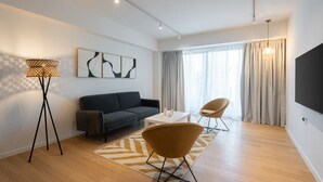 Un salon moderne comprenant un canapé, deux fauteuils, une table basse et un lampadaire.