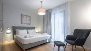 Une chambre d’hôtel moderne, équipée d’un lit, d’une chaise et d’une fenêtre avec des rideaux.