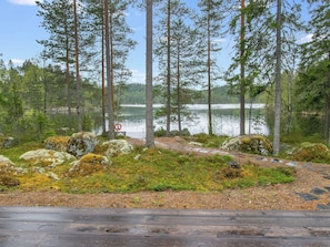 Skovområde med en sø, en træterrasse og en redningskrans.