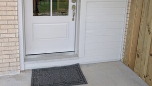 A white front door with a glass panel, a metal handle, and a keyhole.