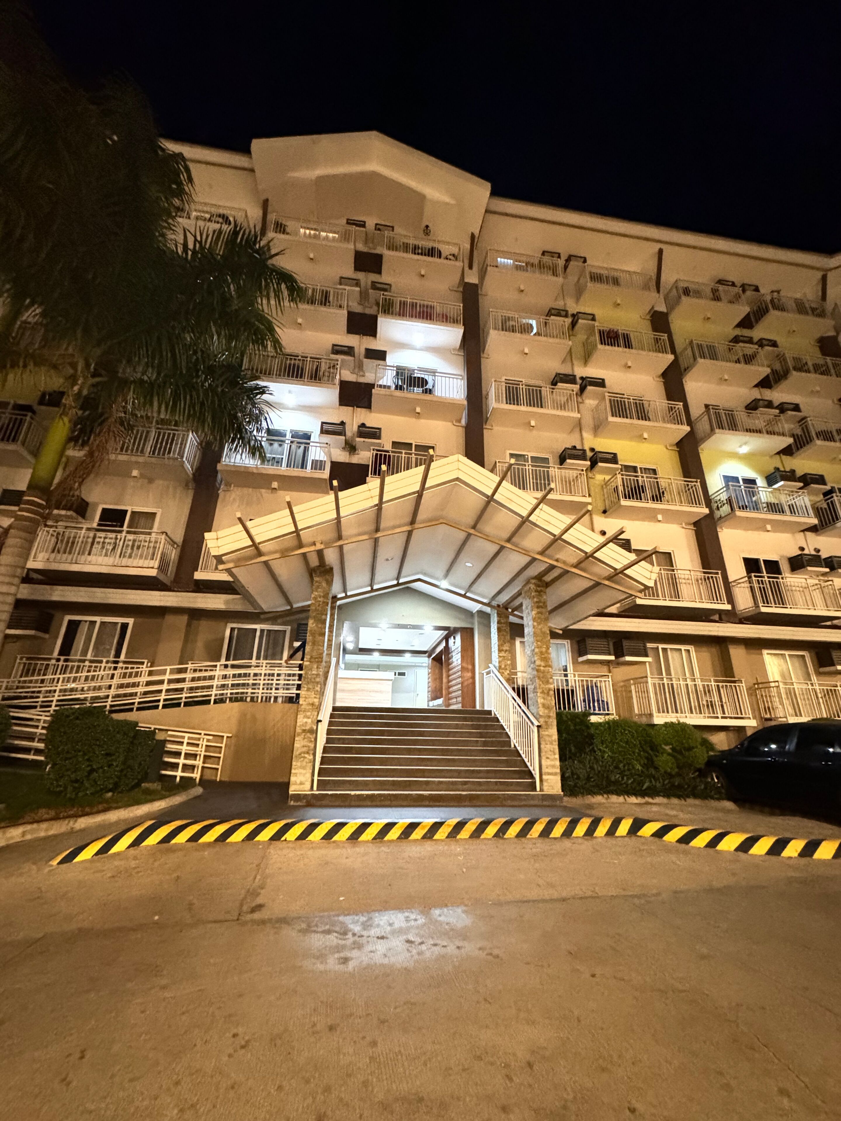 Un edificio de varios pisos con una escalera central que conduce a la entrada.