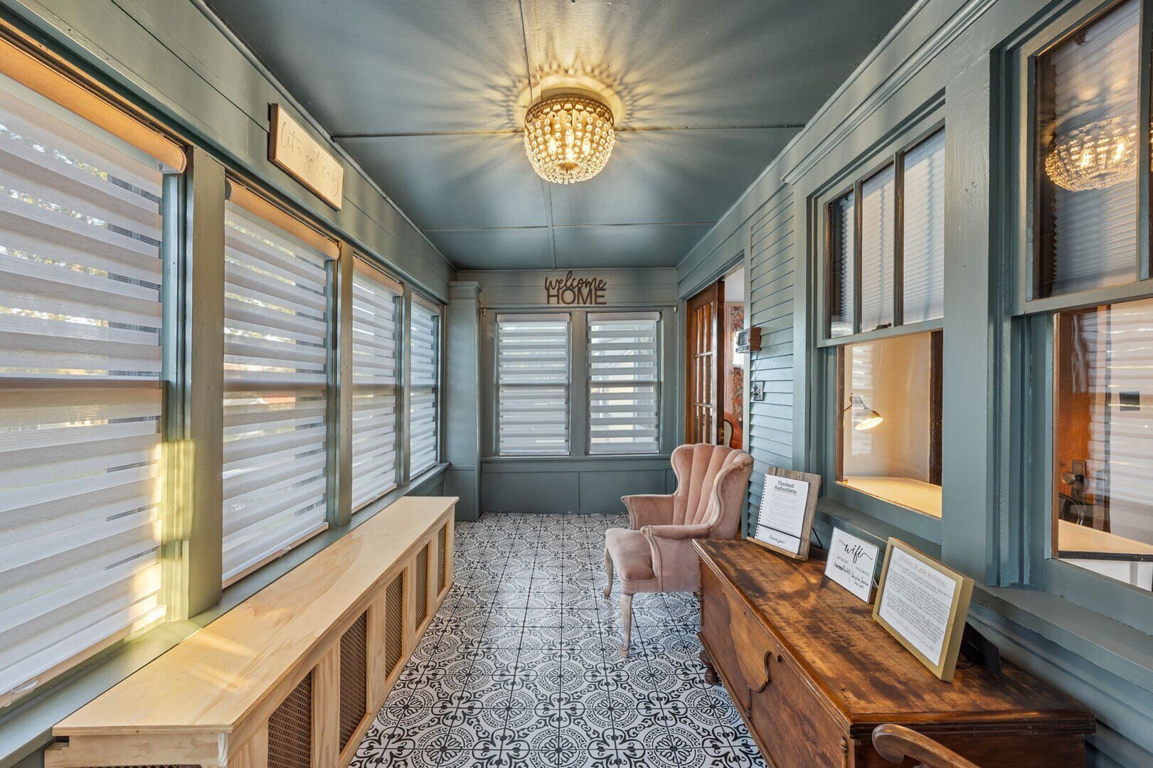 A cozy room with a bench, a wooden chest, and a chandelier.