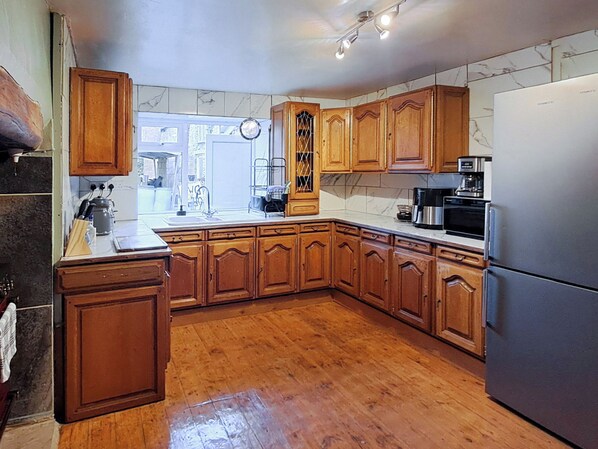 A kitchen with wooden cabinets, a stainless steel refrigerator, and a microwave.