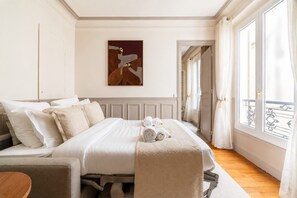 Quarto de hotel com cama, um quadro na parede e vista para o exterior.