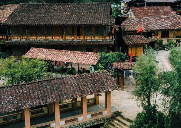 Un pueblo tradicional con edificios de techo de paja, un patio central y una calle estrecha.