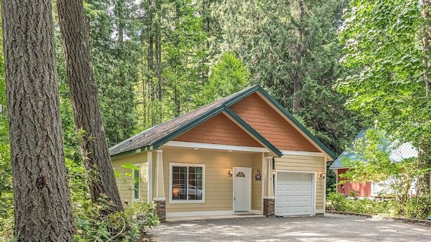 A single-story building with a garage, surrounded by trees. - Fairway Paradise | AC, Hot Tub, BBQ (Packwood)