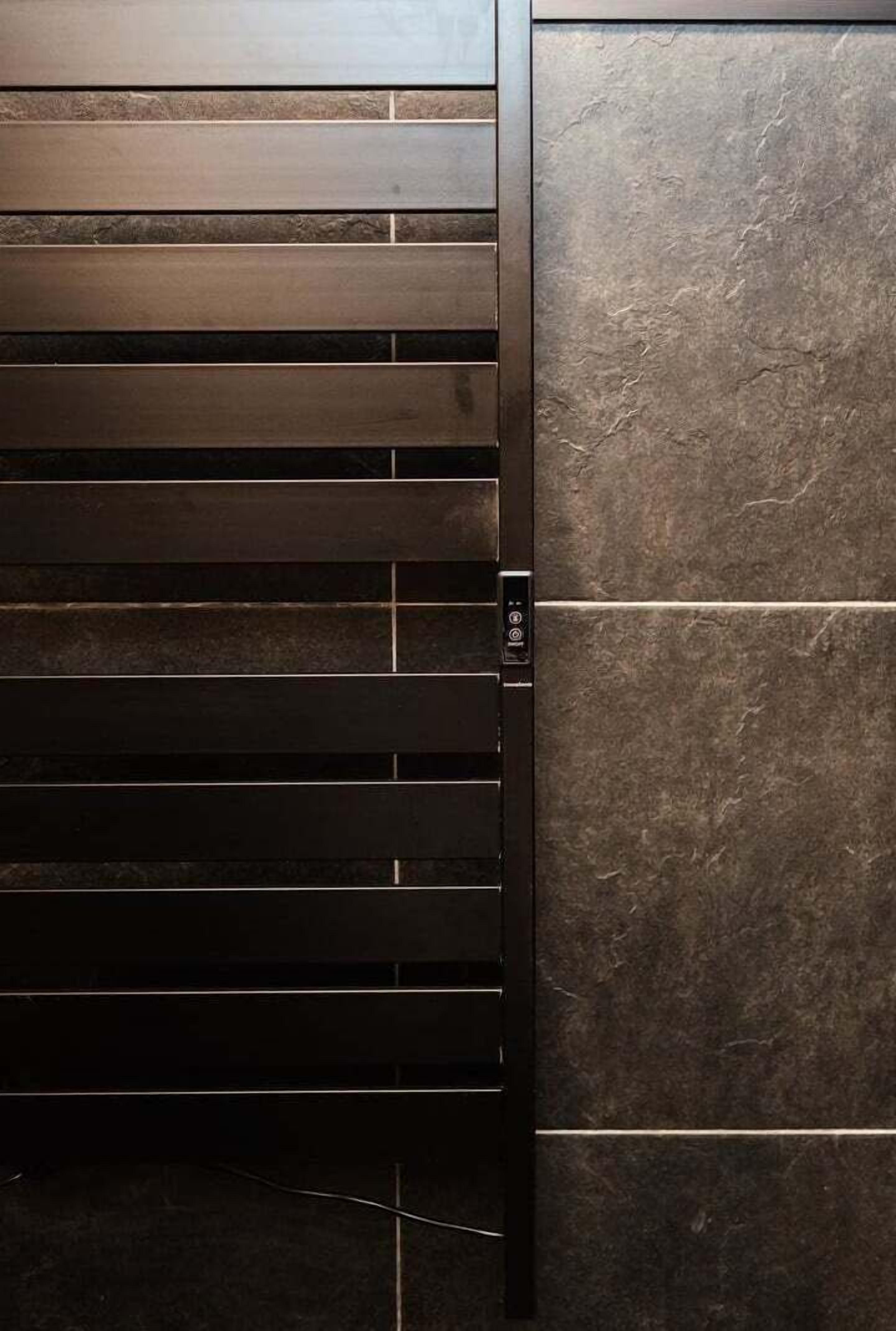 A wall with horizontal wooden slats and a section of dark stone tiles.