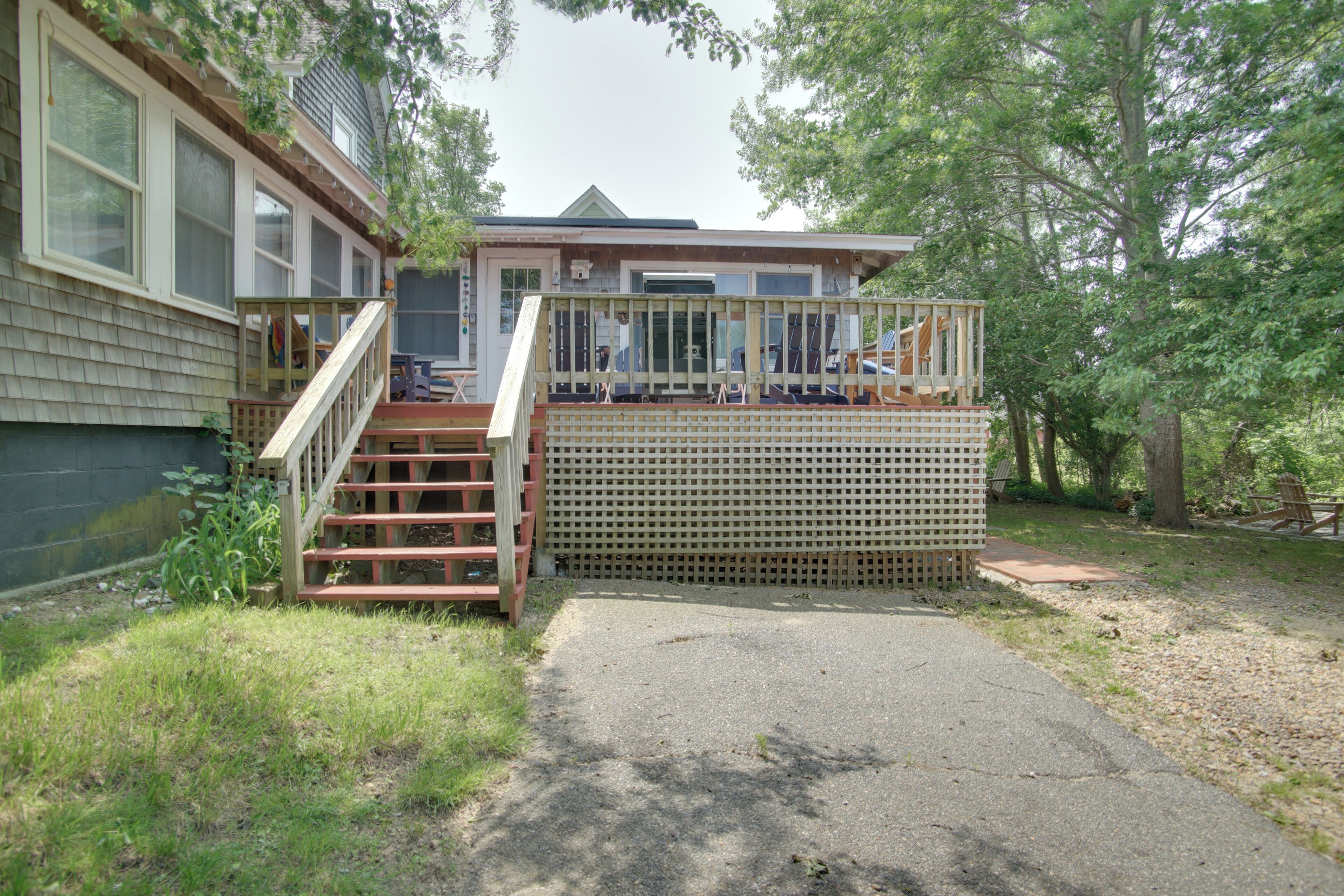 A house with a deck and stairs leading to a covered porch area.