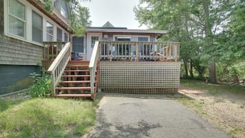 A house with a deck and stairs leading to a covered porch area.