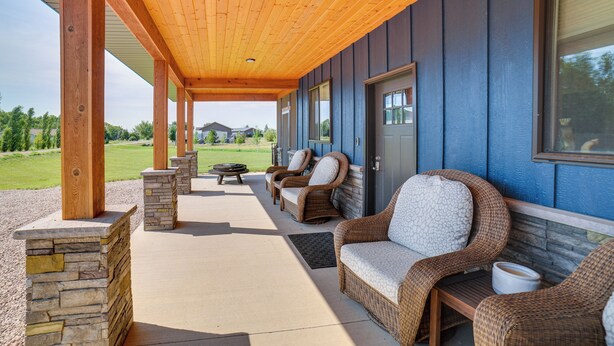 A covered patio area with wicker furniture and stone pillars. - Missouri River Retreat < 1 Mi to the Water! (Pierre)
