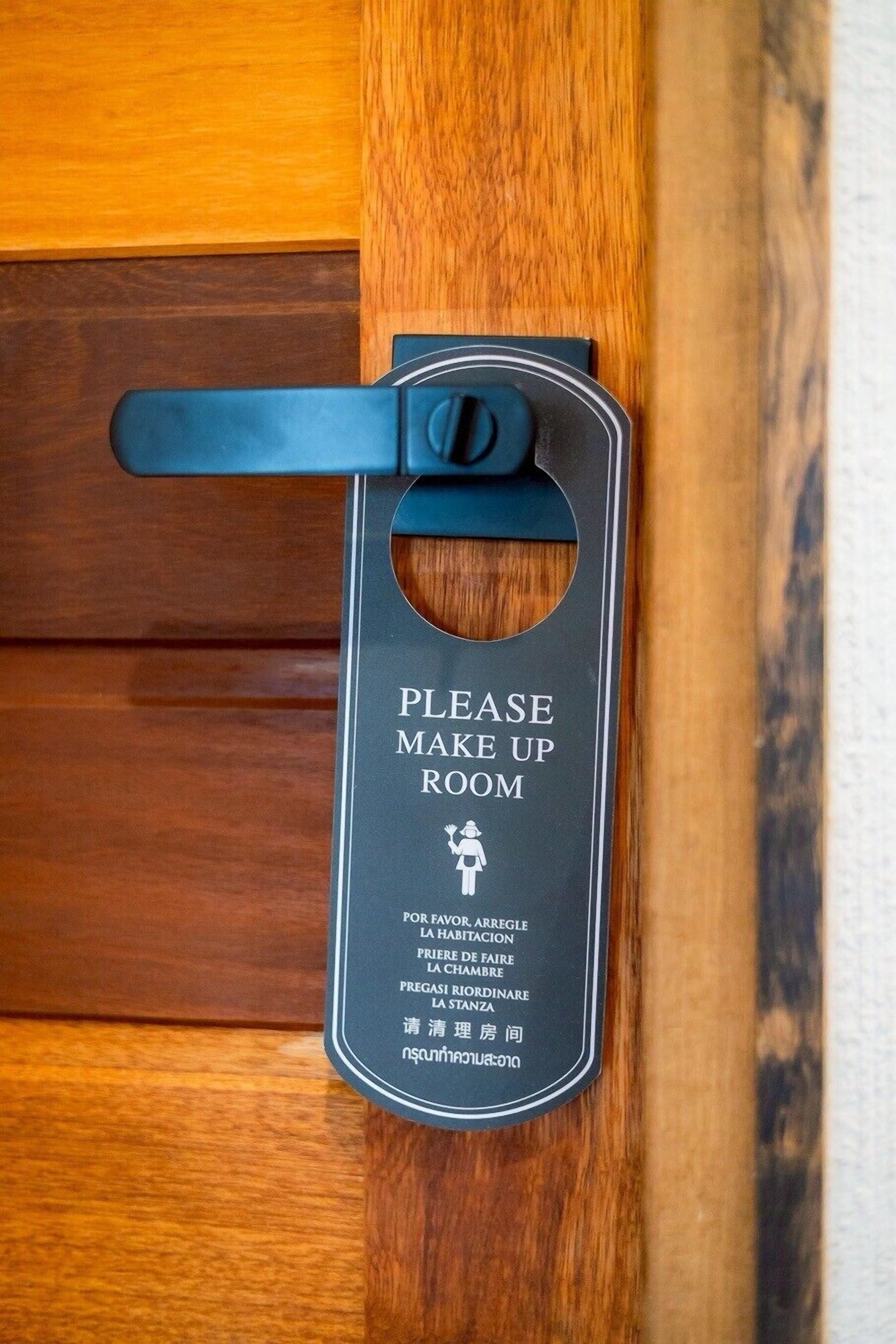 Une porte sur laquelle est affiché un panneau demandant de faire le ménage dans la chambre.