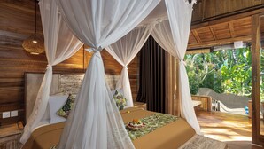 A four-poster bed with a canopy, a wooden headboard, and a view of lush greenery outside. - Nava Prana Villa by GenuineHost (Payangan)