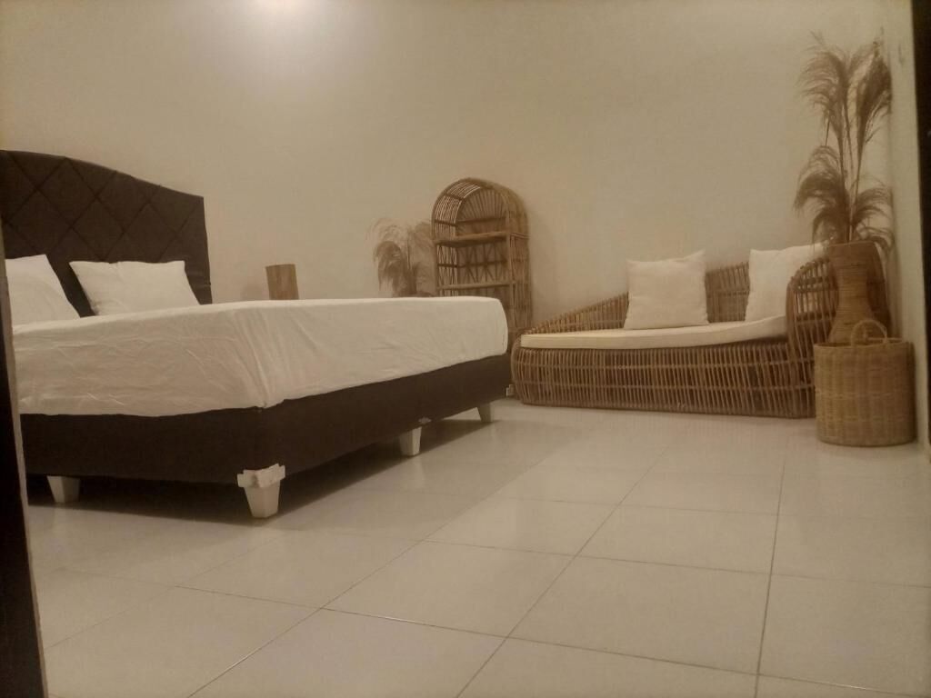 A bedroom with a large bed, a sofa bed, and a small seating area.