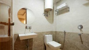 Une salle de bain avec des toilettes, un lavabo et une douche.