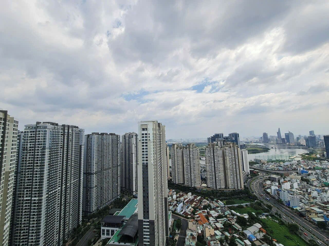 A high-rise residential area with multiple apartment buildings, a river in the background, and a highway to the right.