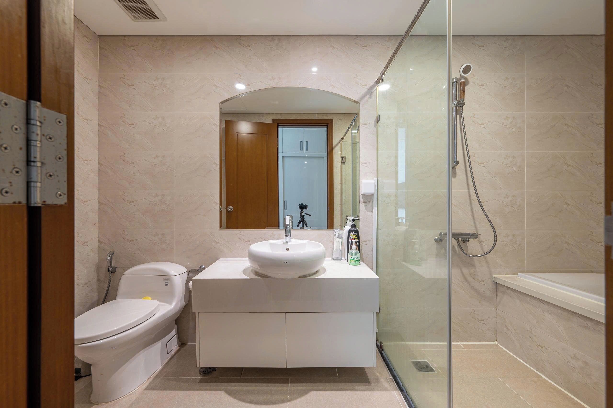 A modern bathroom with a toilet, sink, and shower.