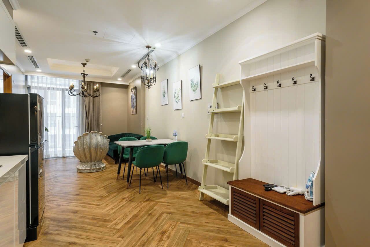 Ein Hotelzimmer mit Essbereich, einer Kandelaber, einem weißen Schrank und Holzboden.