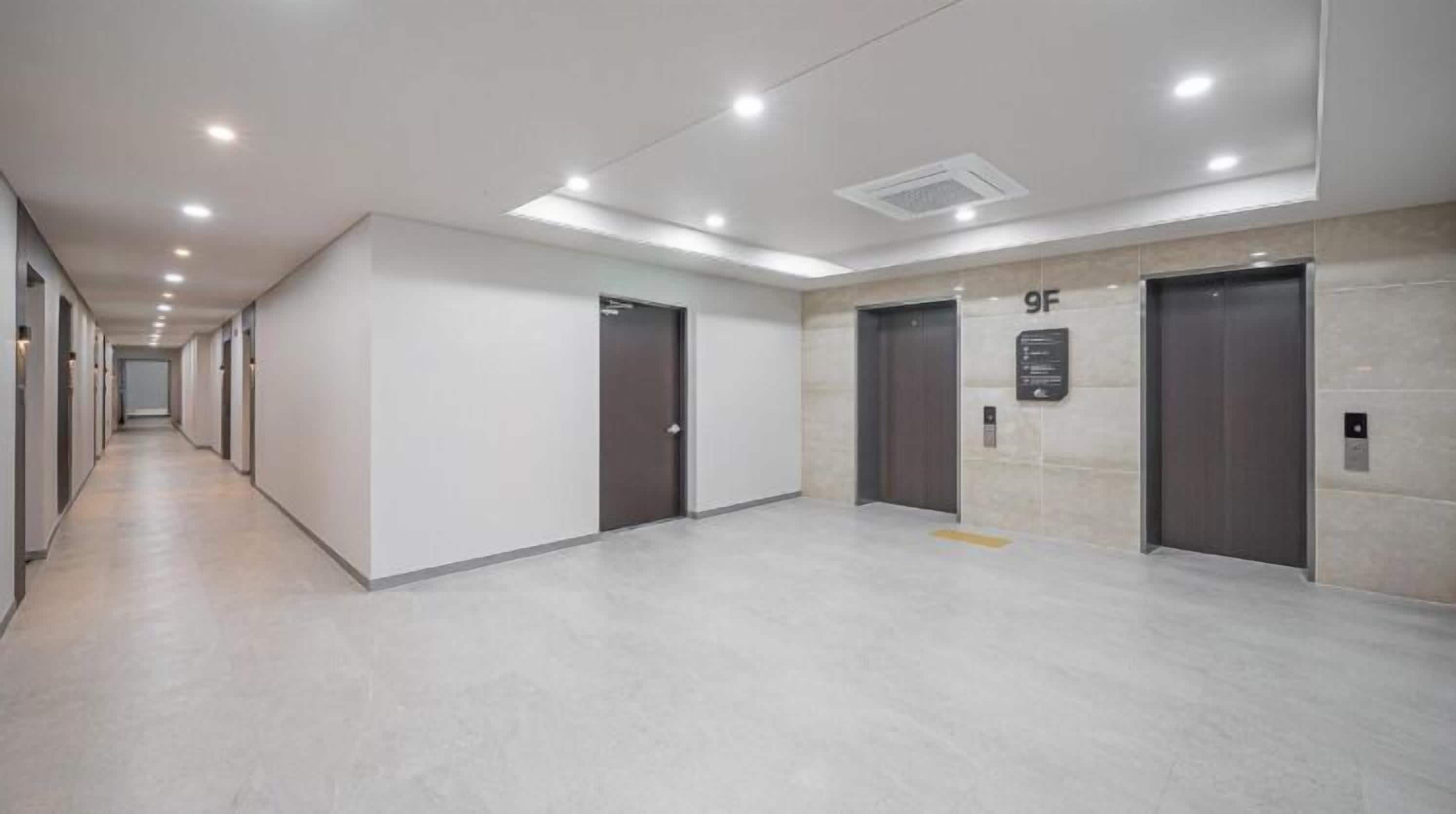 A modern hallway with elevators, a clear floor plan, and a sign indicating the 9th floor.