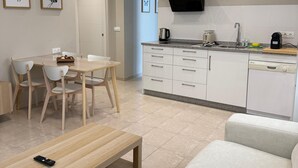 Een moderne keuken met witte kasten, een inbouwoven en een zwarte afzuigkap.