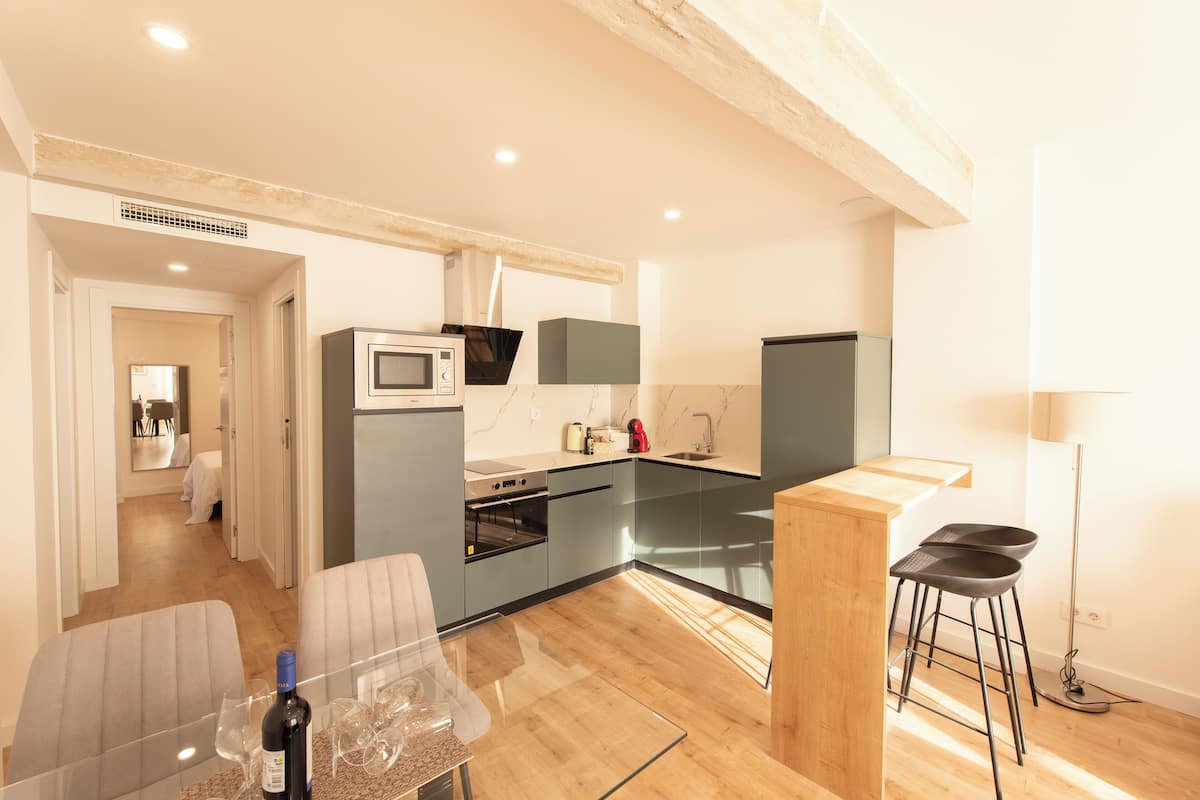 A modern kitchen with a wooden island, a microwave, and a refrigerator.