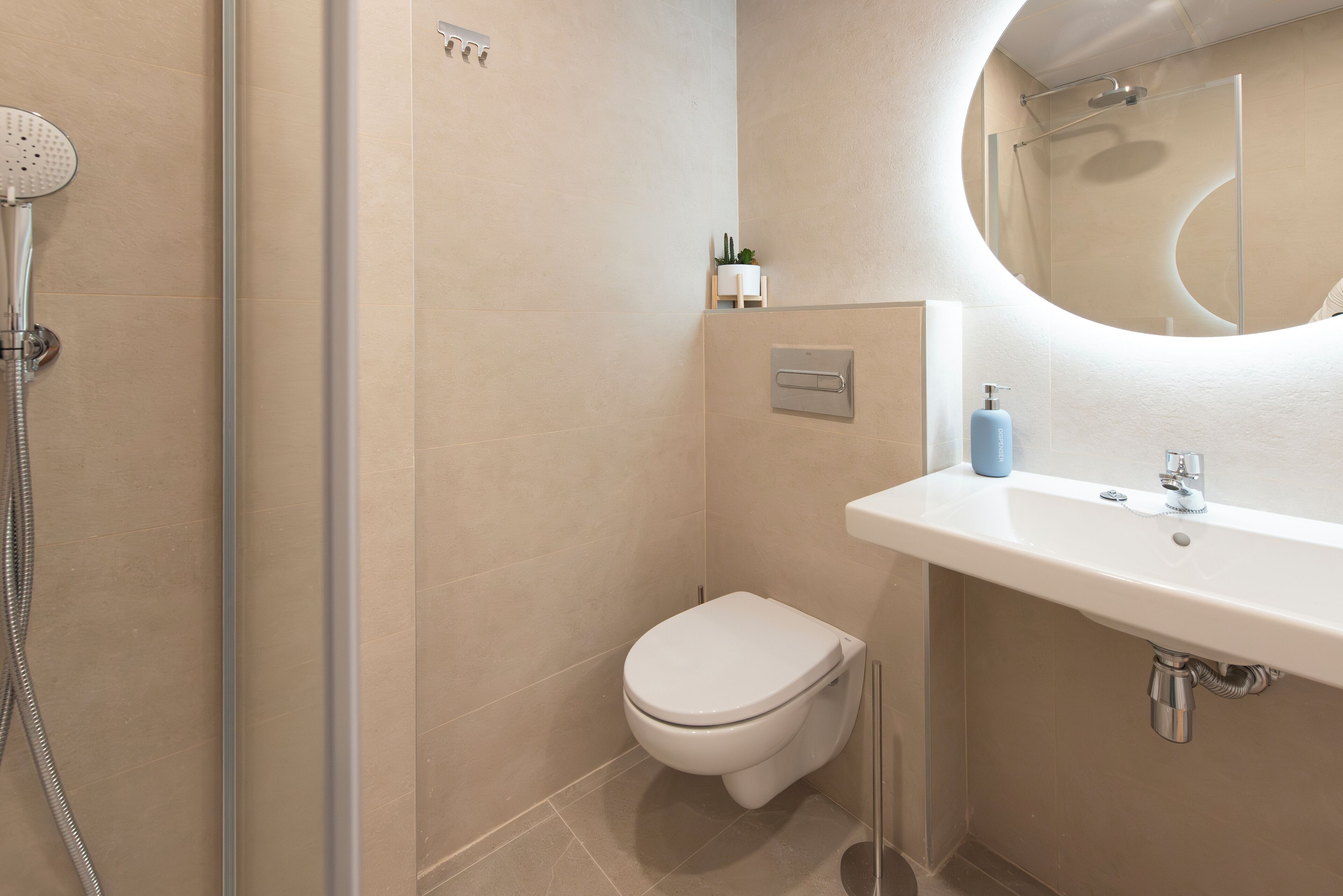 A modern bathroom with a shower, toilet, and sink.