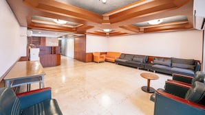 A spacious lobby with a reception desk, seating area, and a modern ceiling design. - Glory hotel (Luodong)