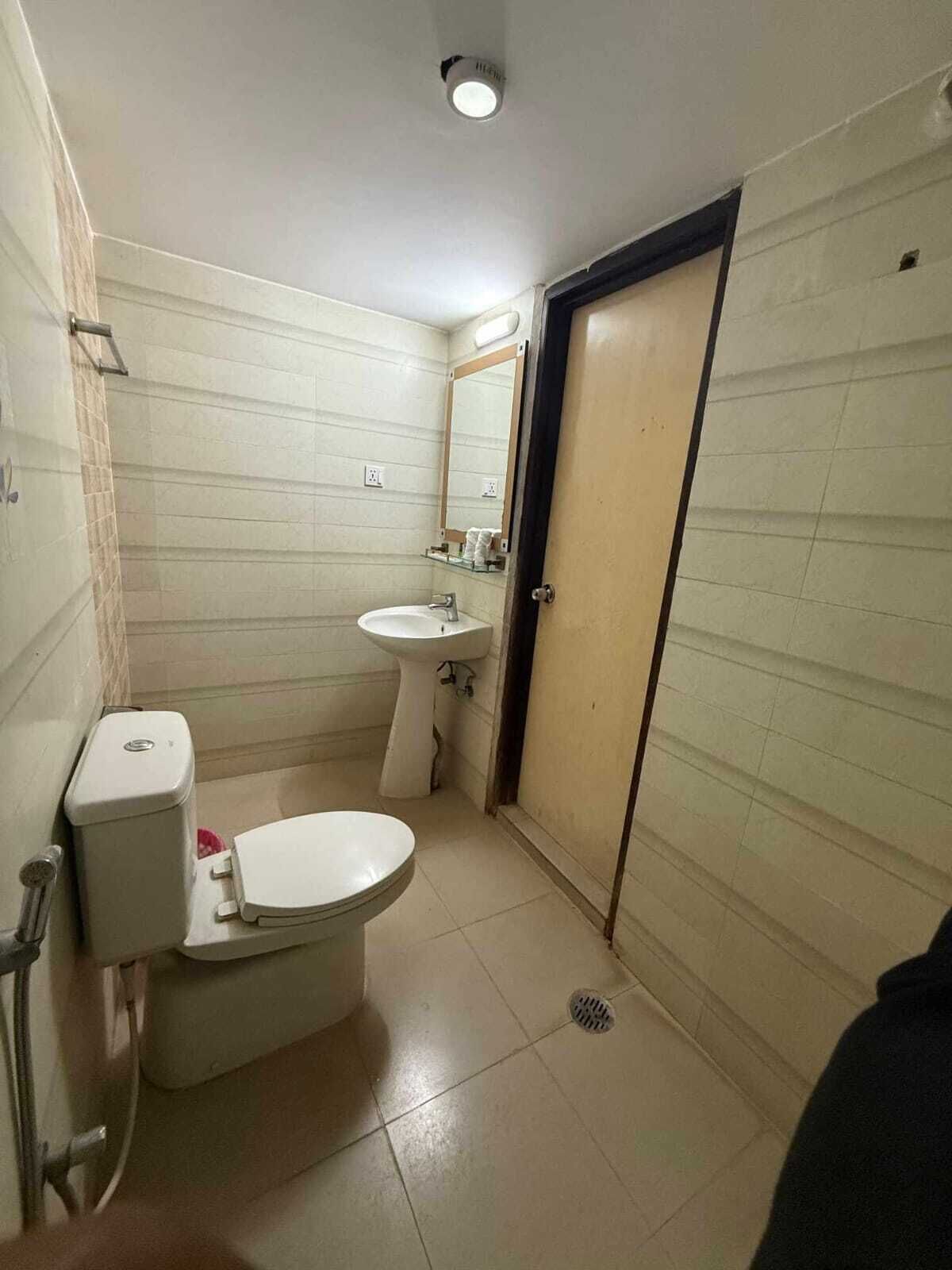A small bathroom with a toilet, sink, and mirror.