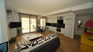 Een modern appartement met een woongedeelte, keuken en eethoek.