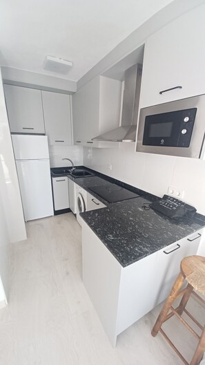 Fridge, microwave, coffee/tea maker, cookware/dishes/utensils