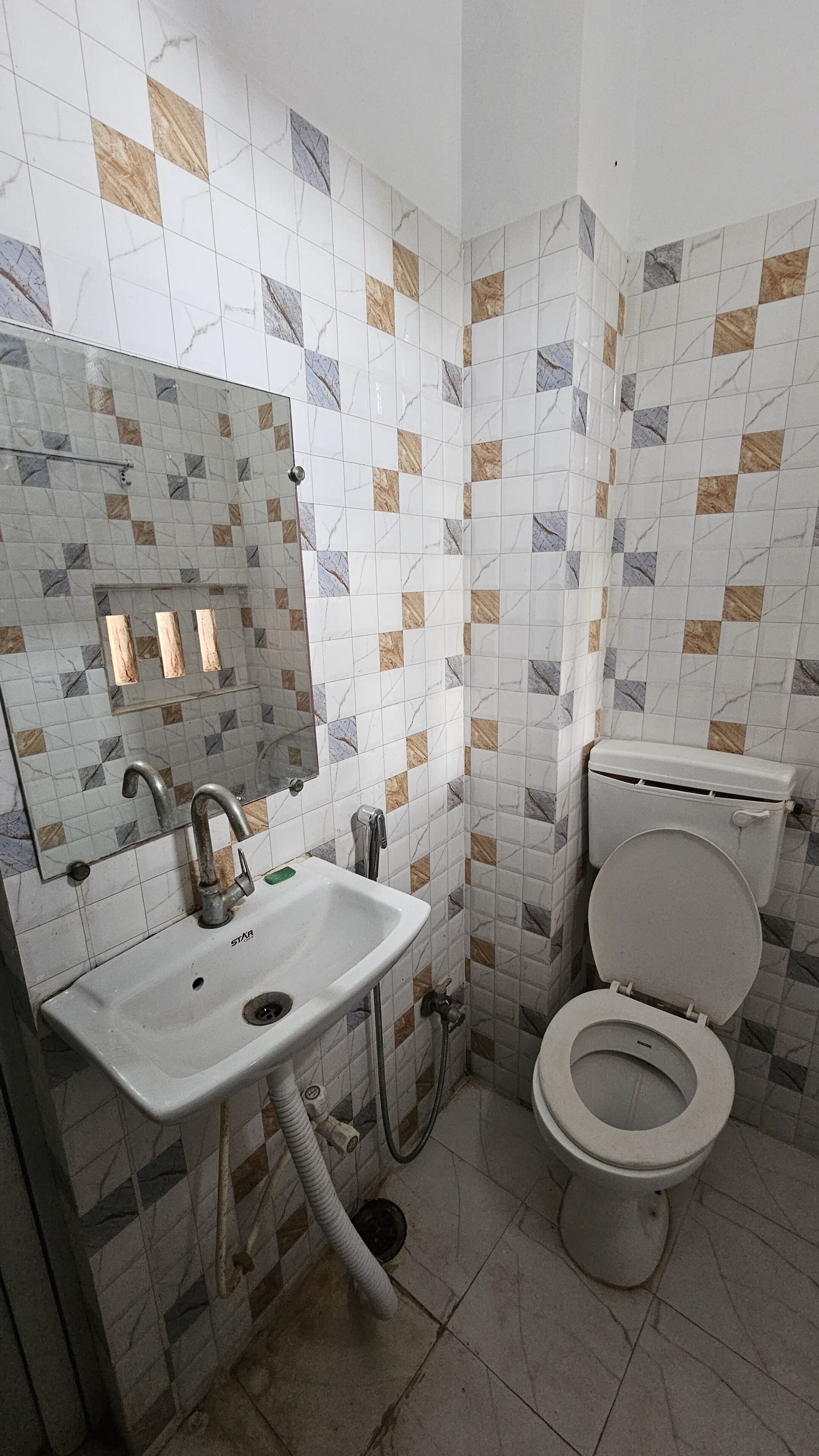 A bathroom with a white sink, a mirror, and a toilet.