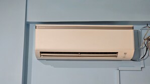 Aire condicionador de paret amb cablejat visible i panell de control.