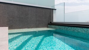 A rooftop swimming pool with clear blue water and a modern design.