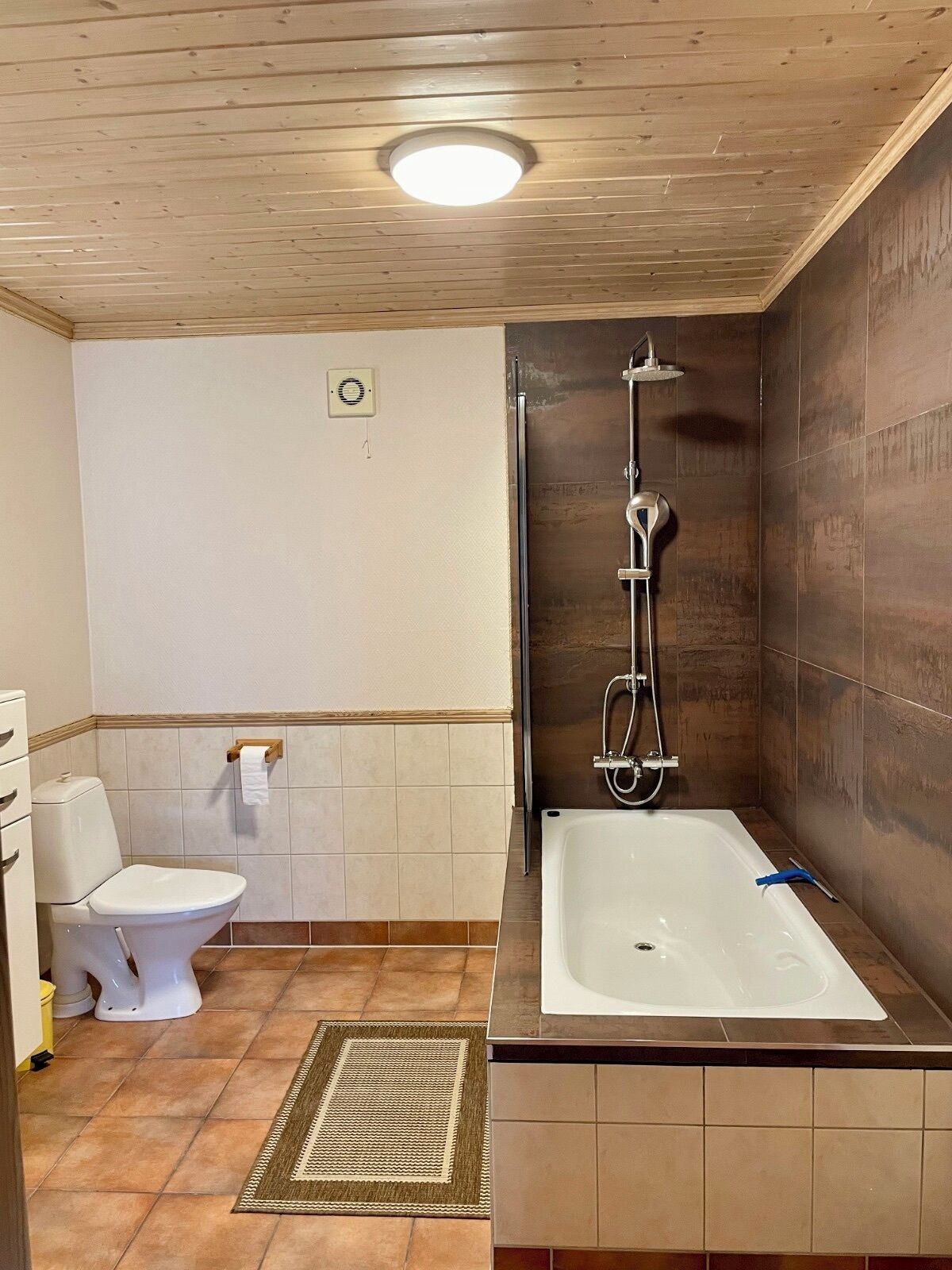 A bathroom with a toilet, a shower, and a bathtub.