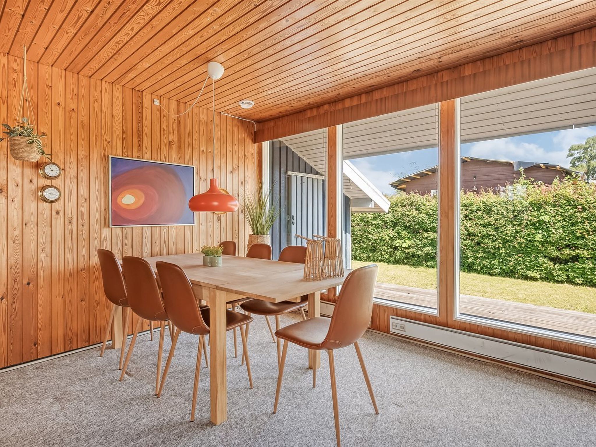 Un espace de restauration moderne avec un plafond en bois, une grande fenêtre et une vue sur l’extérieur.