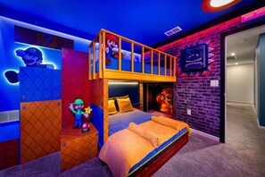Quarto com cama beliche, parede decorada com tema do Mario e estátua do Mario.