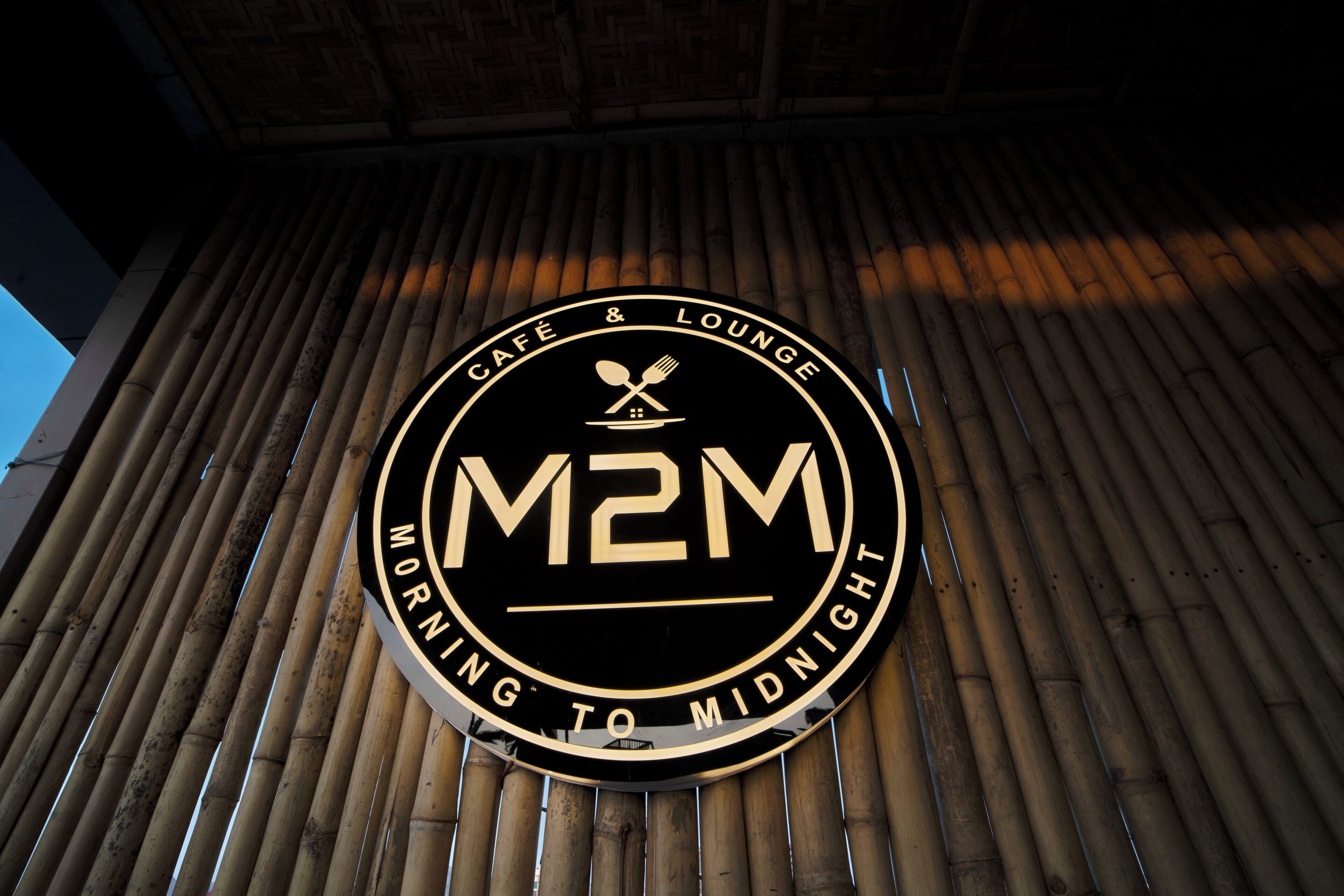 A circular sign with the text "M2M" and "Café & Lounge" indicating a facility.
