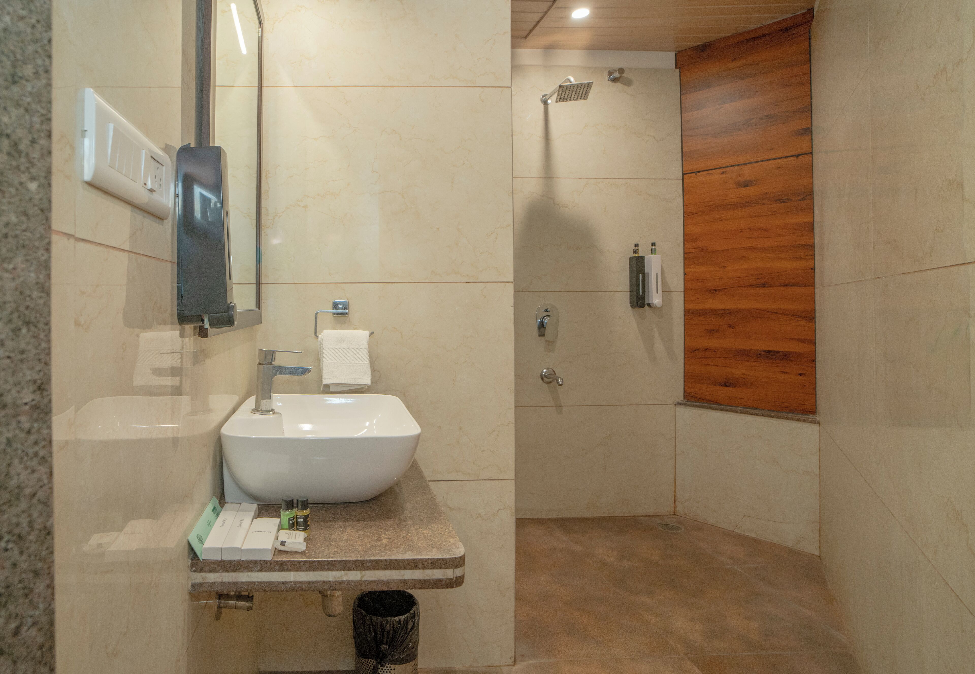 A modern bathroom with a sink, mirror, and shower.