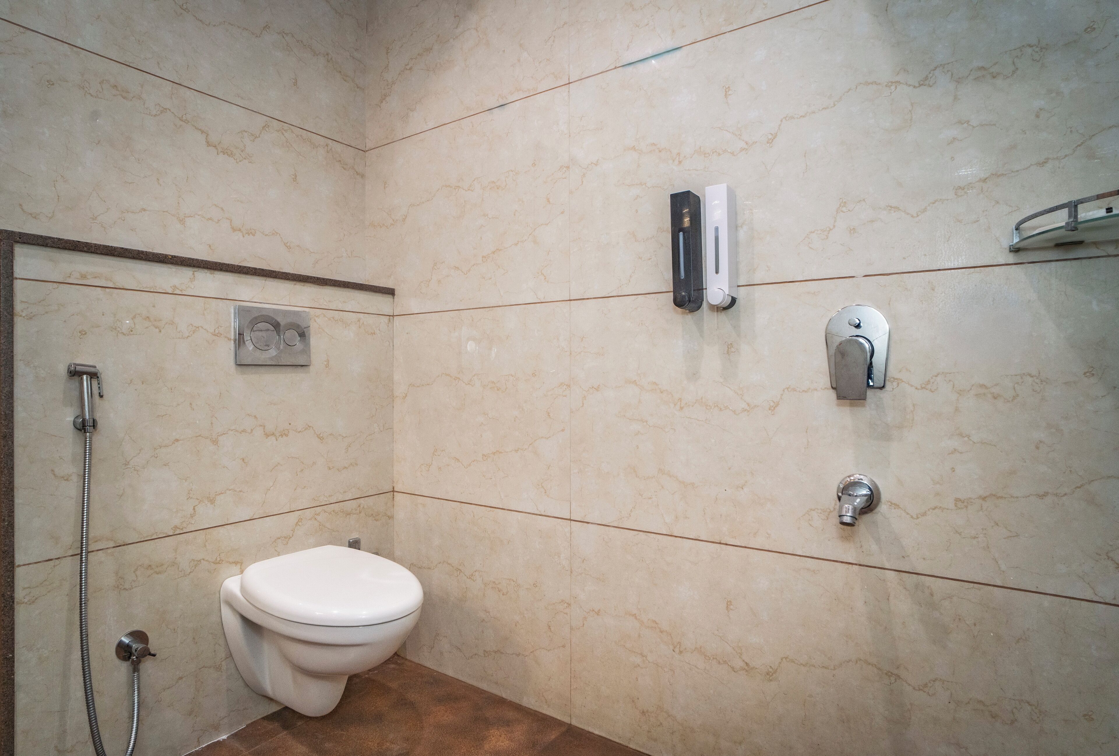 A bathroom with a toilet, a shower, and a hand dryer.