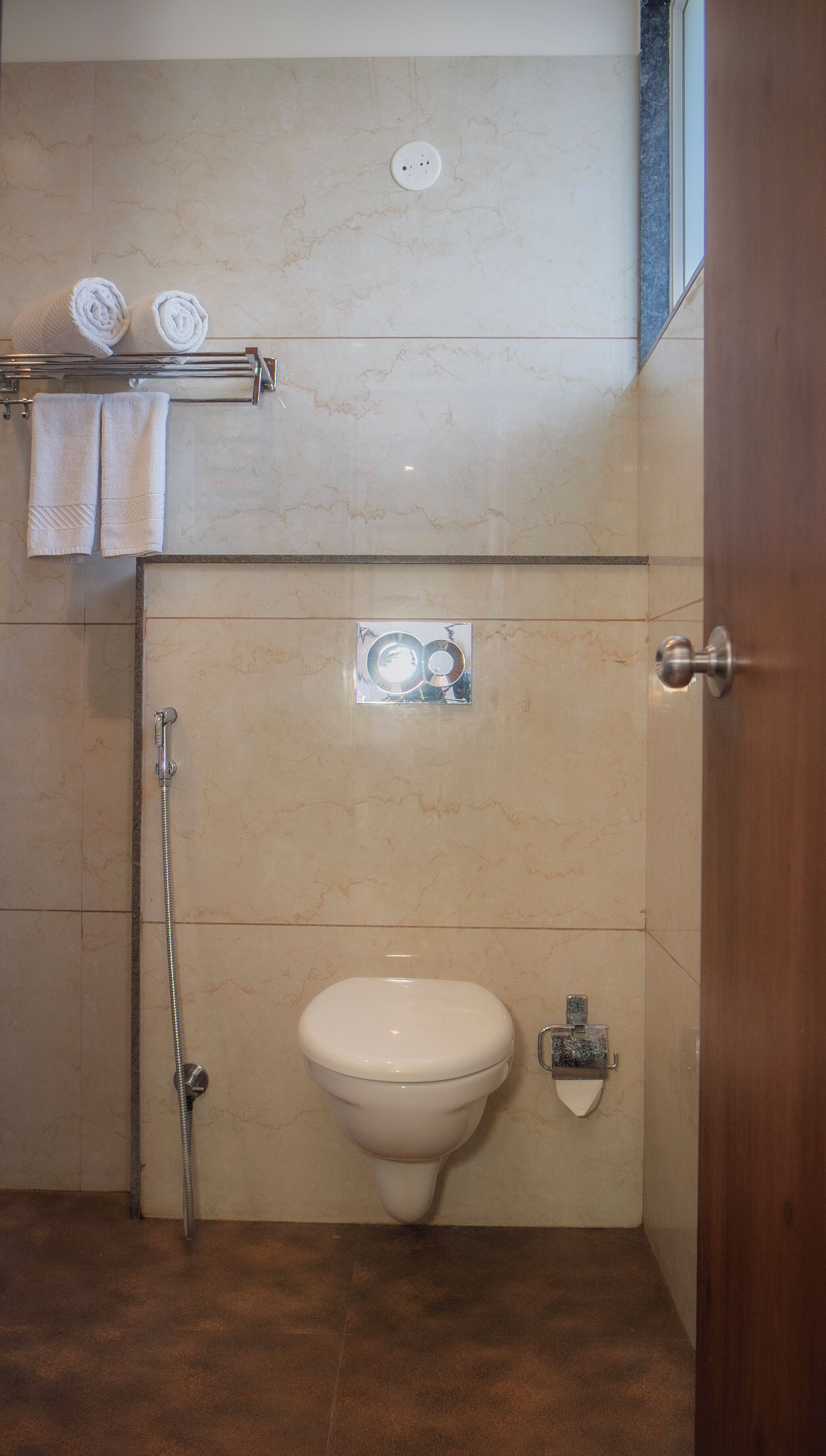 Un baño con inodoro, ducha y toallero con toallas.