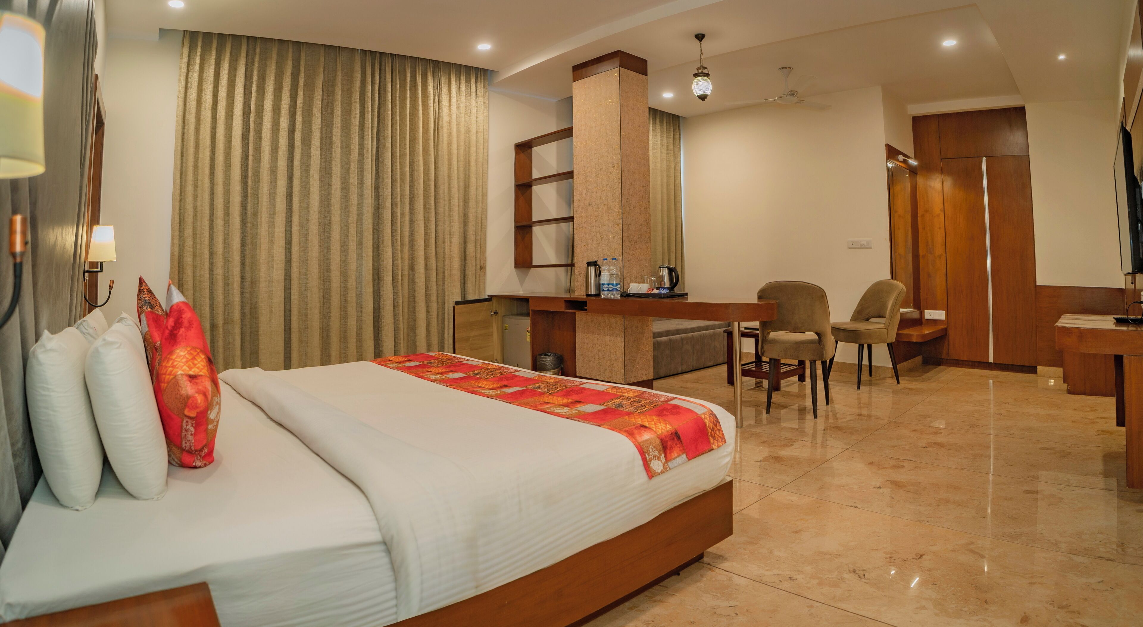 Una habitación de hotel con cama, escritorio, silla, armario y baño.