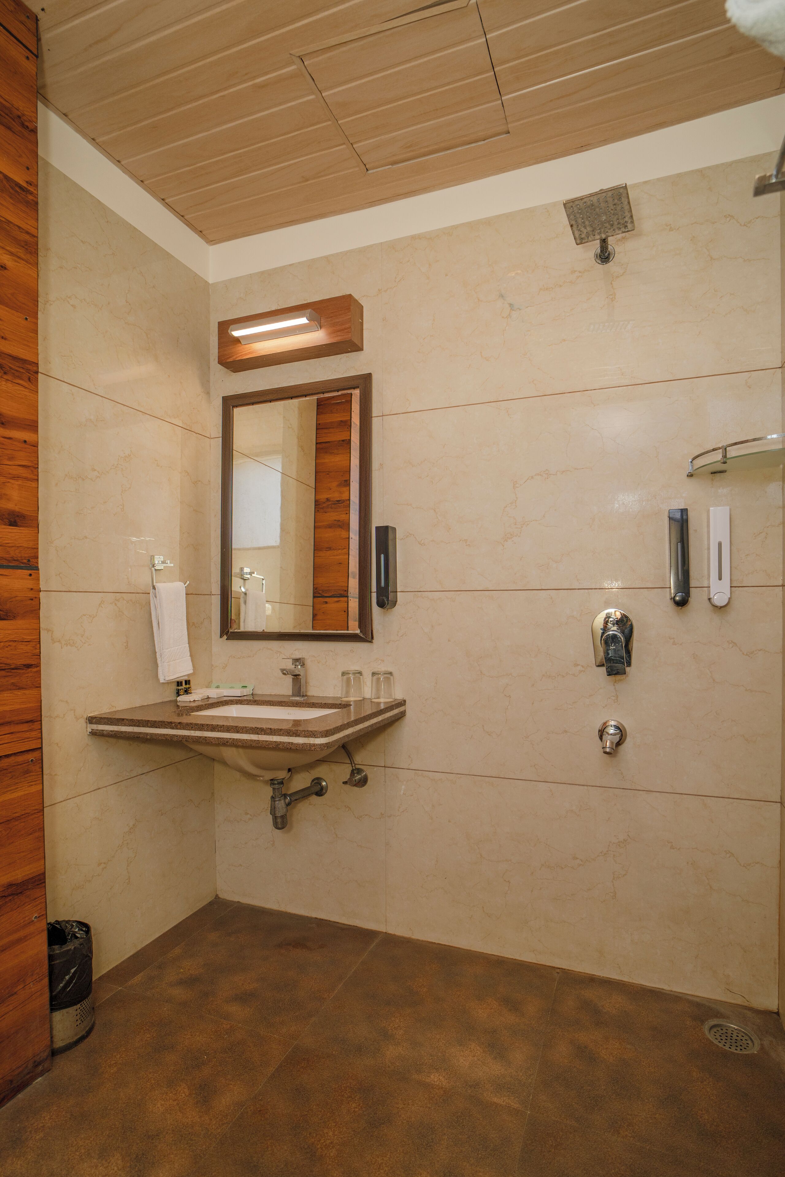 A bathroom with a wooden ceiling, a sink with a mirror, a shower, and a towel rack.