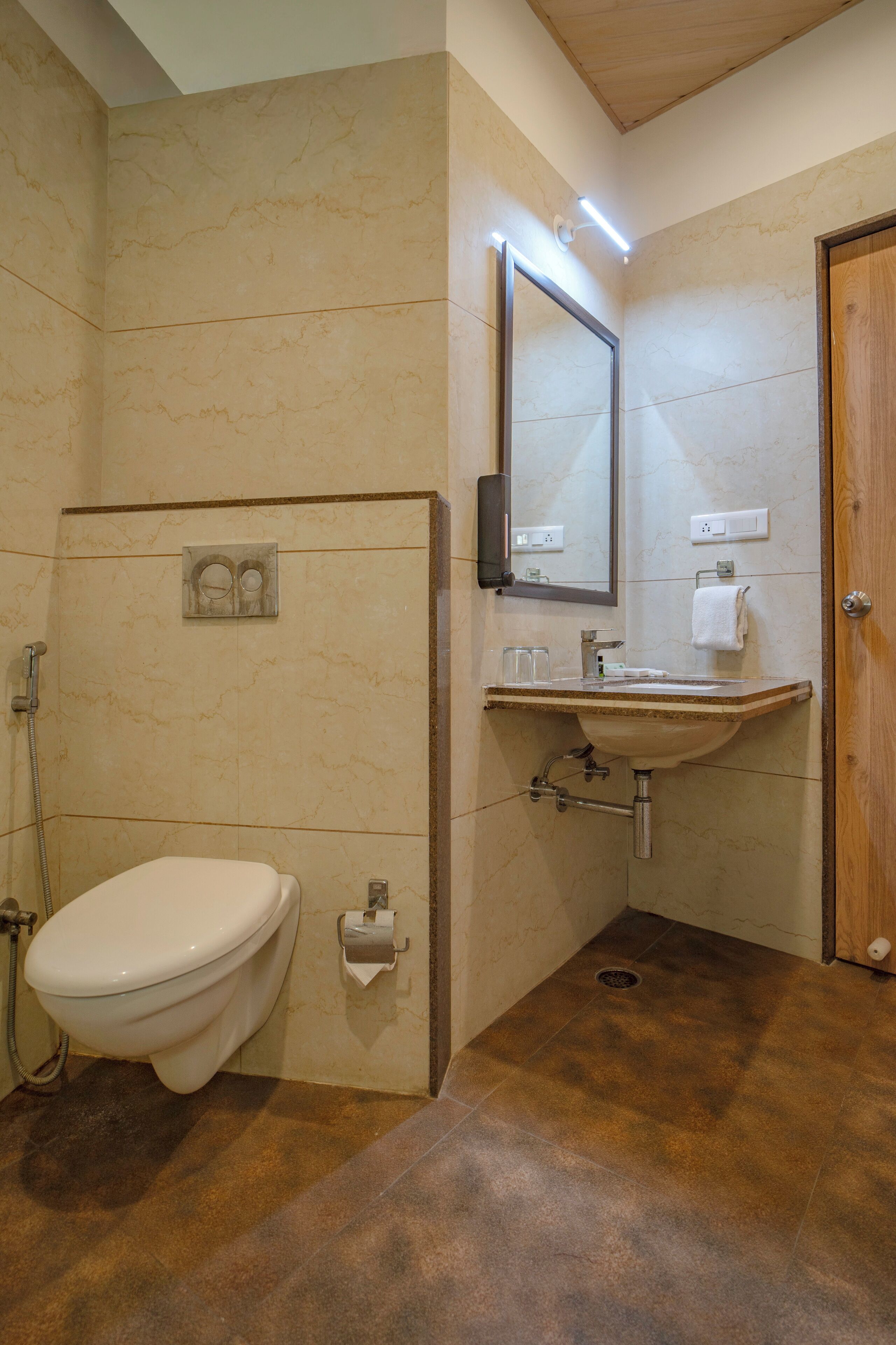 Un baño con inodoro, lavabo, espejo y ducha.