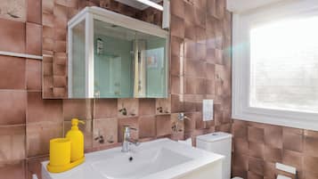 Een haardroger, handdoeken, zeep, toiletpapier