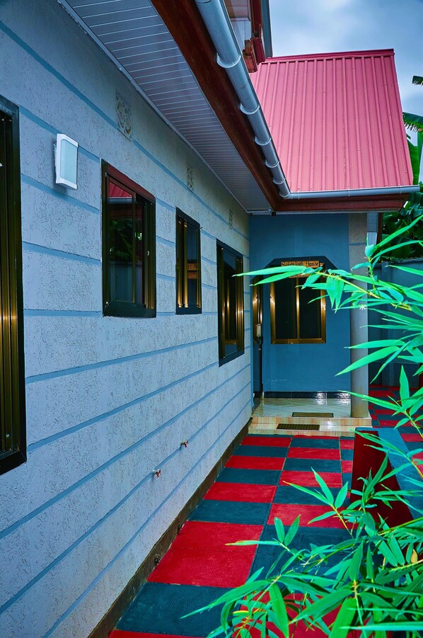 Un edificio con techo rojo, pared exterior azul y piso a cuadros rojo y azul.