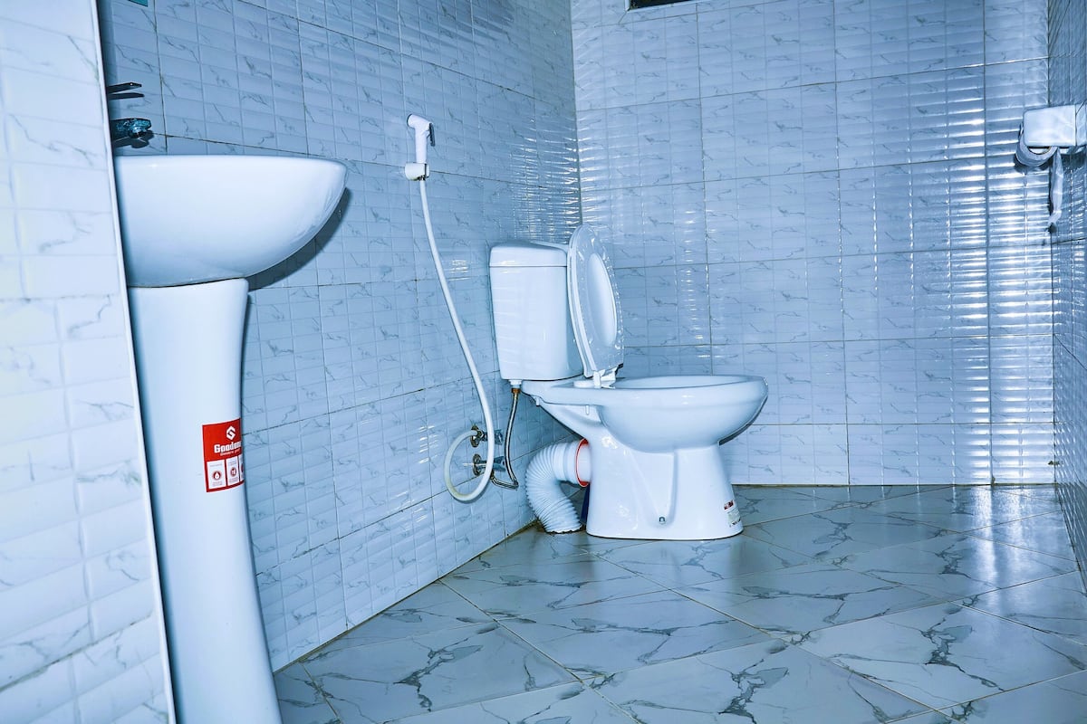 Ein Badezimmer mit Toilette, Waschbecken und gefliesten Wänden.
