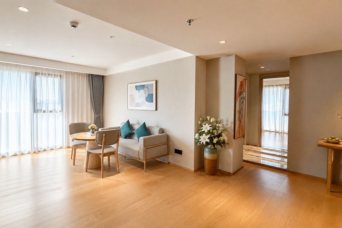 A spacious living area with a sofa, chairs, a coffee table, and a vase of flowers.
