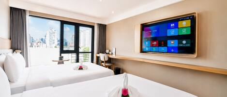 A hotel room with two beds, a flat-screen TV mounted on the wall, and a view of the city through large windows.